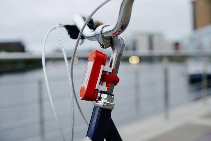 Buffalito handheld power bank and lamp by BuffaloGrid, clipped to a bicycle handlebar