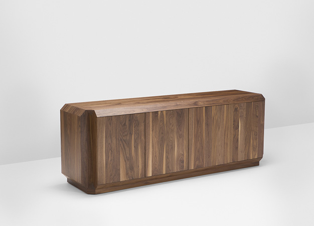 Low walnut Hayche sideboard with four faceted doors in a studio setting