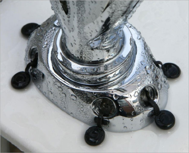 Close-up of the chrome Plumis fire suppression device fitted around the base of a kitchen tap